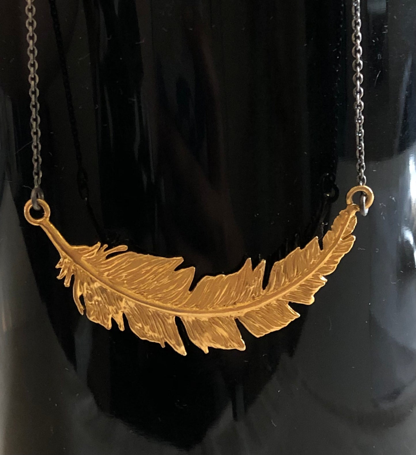 Collar pluma curva dorada